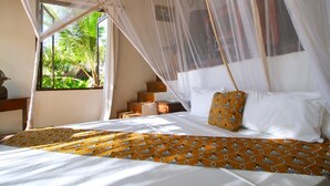 A bed with a canopy, white bedding, and a patterned bedspread. - VILLA CHANI - Four Bedroom Villa, Sleeps 12 (Zanzibar)