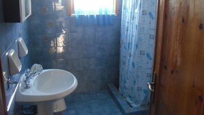 Un baño con lavabo, espejo y paredes de azulejos.