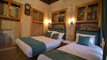 A room with two beds, wooden cabinets, and a clock on the wall.