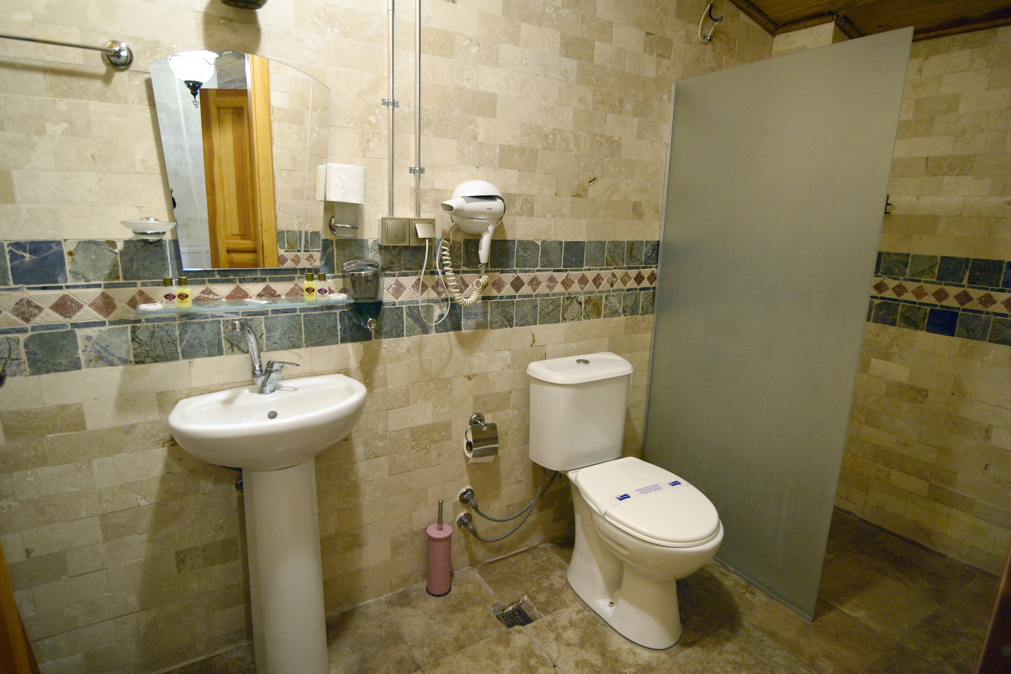 A bathroom with a sink, toilet, and hairdryer.