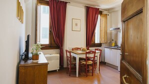 Una cocina compacta con mesa y sillas, refrigerador y estufa.