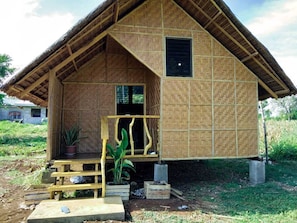 A small, single-story building with a thatched roof and a wooden door.