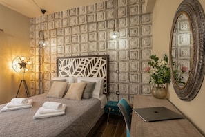 Relax in a classic room with a large bed, seating area, and decorative panel.