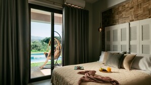A bedroom with a large bed, a view of a swimming pool, and a wooden wall panel. - Views, Pool, Garden, BBQ, Playground, Tennis Table (CHANIA)