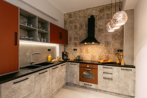 Enjoy cooking in this well-lit kitchen with an oven, stainless steel sink, and ample storage.