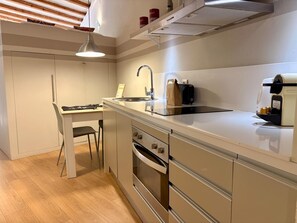 A modern kitchen with a built-in oven, a sink, and a coffee machine. - Chic studio in a perfect location in Barcelona (Barcelona)