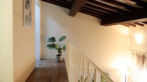 A wooden staircase with a white railing, a potted plant, and a wall-mounted light fixture. - santamarta35: characteristic apartment in a great location (Pisa)