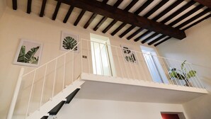 A staircase with white railings and a wooden ceiling. There are framed pictures on the walls and a door at the top of the stairs. - santamarta35: characteristic apartment in a great location (Pisa)