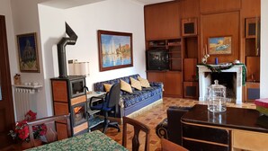 A cozy living room with a sofa, a dining table, a fireplace, and a TV. - Apartment with 2 bedrooms and kitchen (Avezzano)