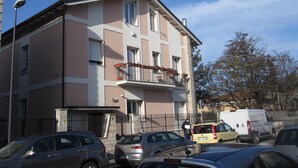 A multi-story residential building with balconies, a gated entrance, and parked cars. - Apartment with 2 bedrooms and kitchen (Avezzano)