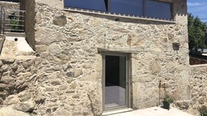 A stone building with a tiled roof, a large window, and a door. - House of Quinteiro de Azagães (Azagães)
