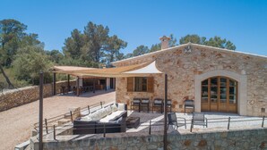 Un bâtiment en pierre doté d’une terrasse extérieure et d’un patio couvert.