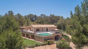 Une villa en pierre dotée d’une piscine, d’un espace salon extérieur et d’un jardin.