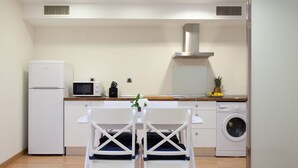 A compact kitchen with a refrigerator, microwave, sink, and washing machine. - Albareda 6 - Two Bedroom Apartment, Sleeps 4 (Sevilla)