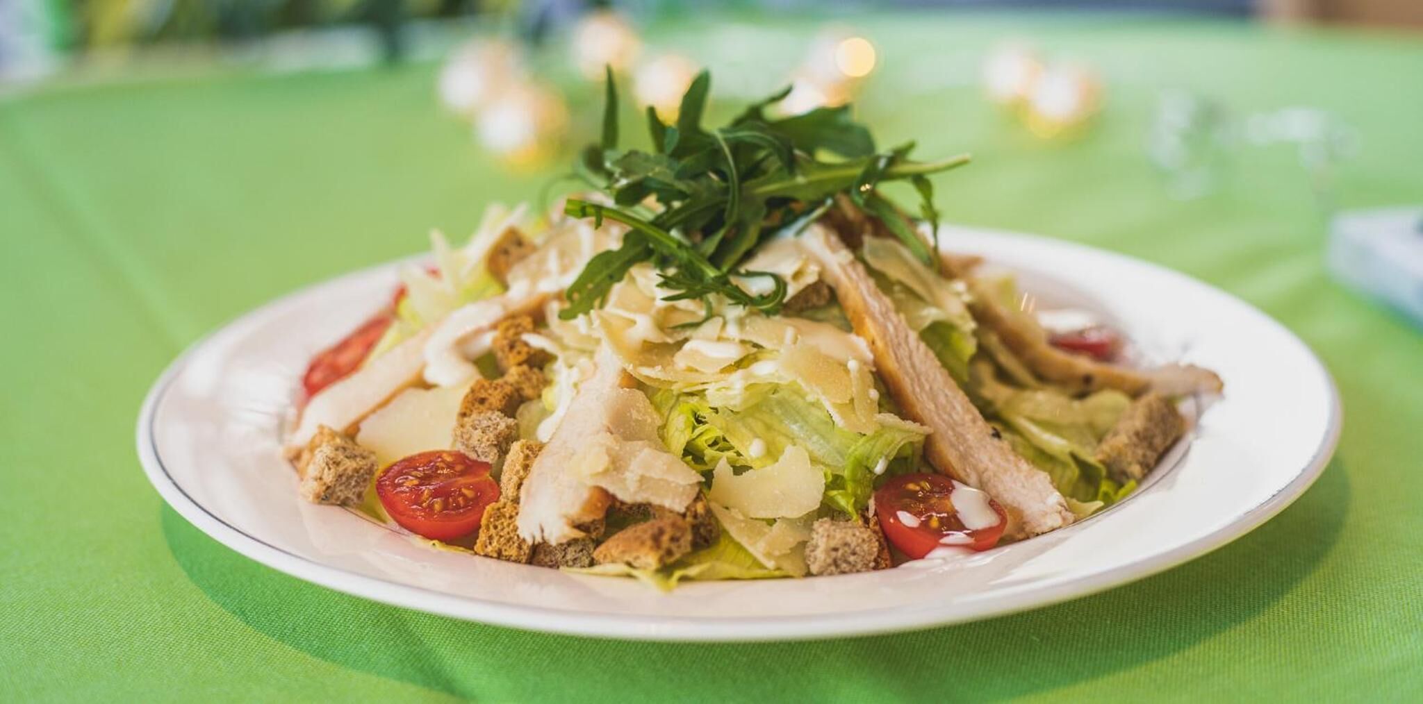 A plate of food with various ingredients including lettuce, tomatoes, and croutons.