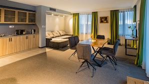 A modern living space with a kitchen, a dining area, and a seating area. - A&M Hotel - Plovdiv (Plovdiv)