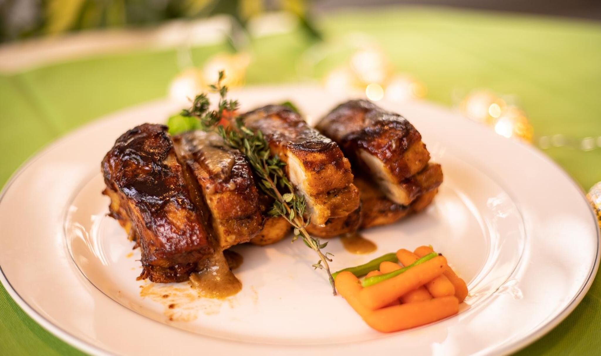 A plate with roasted meat and carrots.