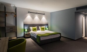 Een minibar, een bureau, een laptopwerkplek, verduisterende gordijnen