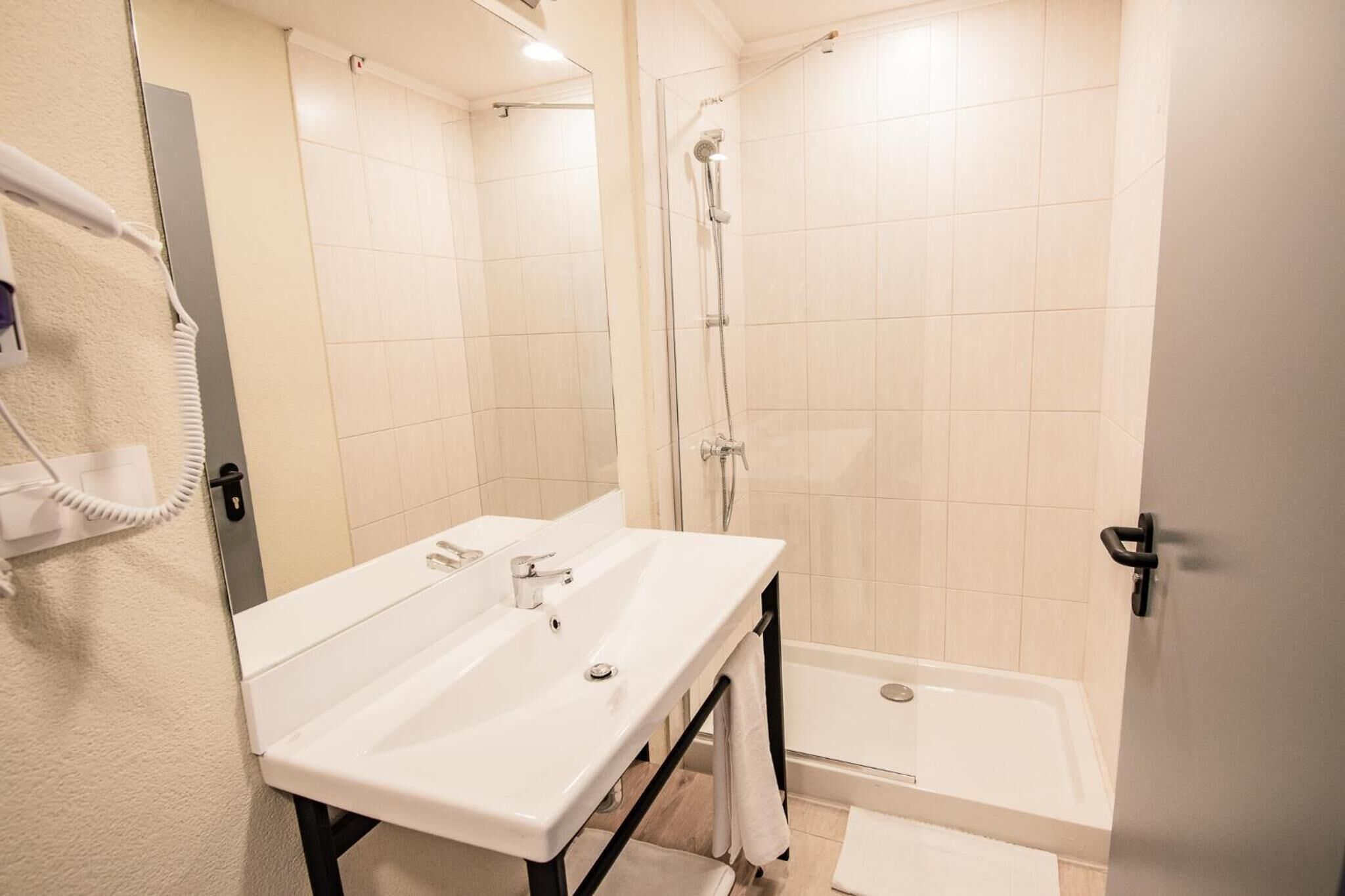 A bathroom with a white sink, a shower, and a toilet.