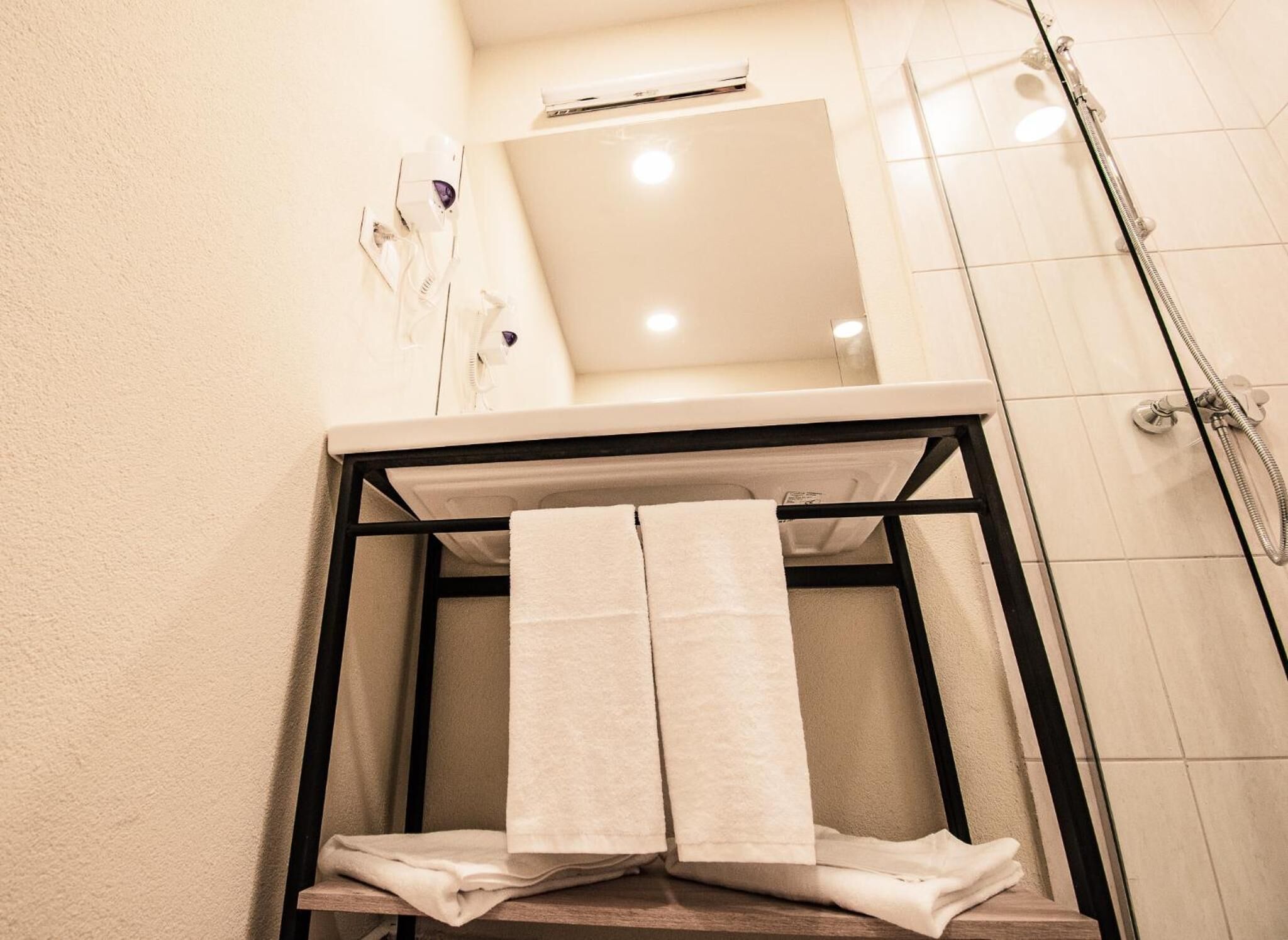 Un baño con ducha, perchero y espejo.