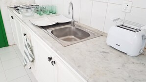 A kitchen with a stainless steel sink, a white toaster, and a marble countertop. - Saltpeter: 1st Beach Line (Caleta de Famara)