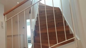 Eine Holztreppe mit weißen Geländern und einem Holzgeländer.