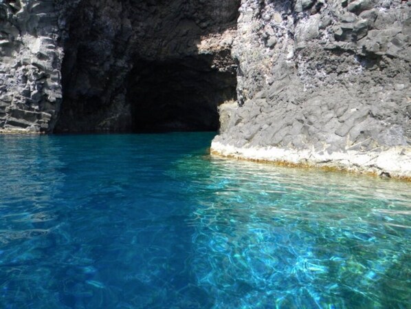 Une piscine d’eau cristalline, entourée de falaises rocheuses.