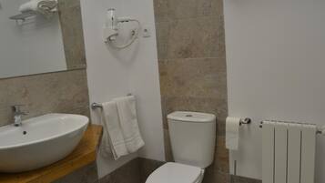 A bathroom with a sink, toilet, towel rack, and a towel hanging on the wall.