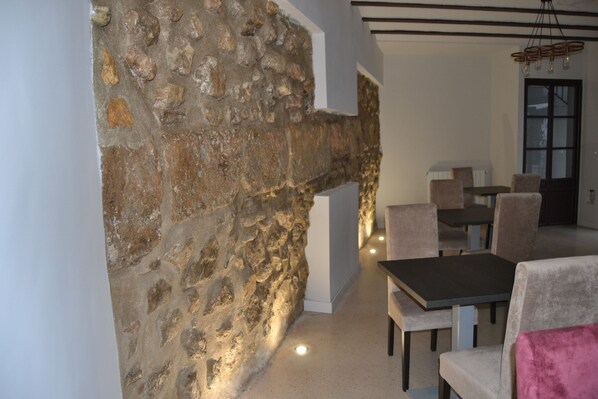 Comedor con paredes de piedra, una mesa y sillas.