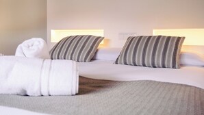 A hotel room with two beds, each with striped pillows and bedside lamps. - Hotel La Vera Cruz (Caravaca de la Cruz)