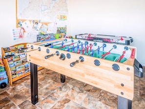 A foosball table in a room with a map on the wall and a rack of tourist information books. - Rivendell Glamping Pod - UK11881 (Holsworthy, near Launceston)