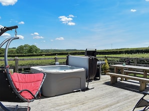 A hot tub on a wooden deck with a view of a grassy field and a wooden fence. - Rivendell Glamping Pod - UK11881 (Holsworthy, near Launceston)