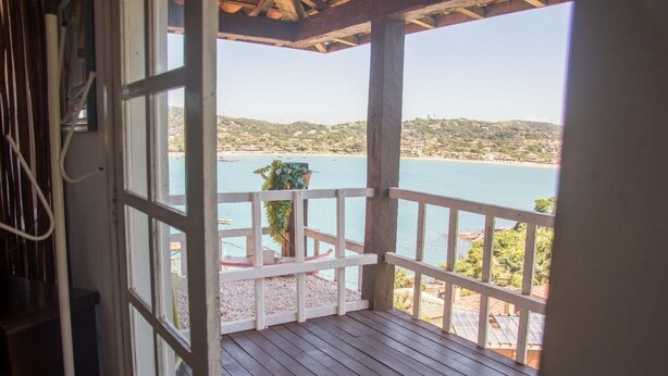 Una terraza de madera con barandilla que da a la costa.