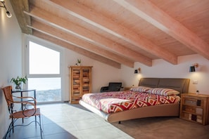 A bedroom with a bed, a desk, a chair, and a view of the city. - Refined villa with minimal chic interior and fabulous private pool with sea view (Ascea)