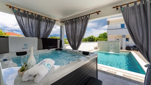 Un área de spa con un jacuzzi, una botella de champán y una toalla.