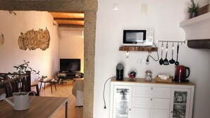 Une cuisine chaleureuse avec une table en bois, des armoires blanches et un four à micro-ondes.
