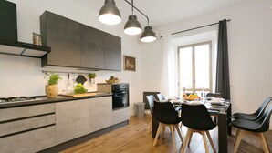 A modern kitchen with a central island, built-in appliances, and pendant lighting. - ⭐ The Colosseum Mansion ⭐ (Roma)