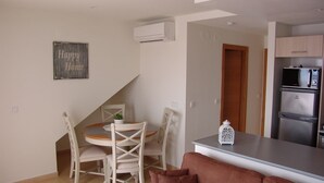 A compact kitchen with a dining area, a refrigerator, and a small table with chairs.