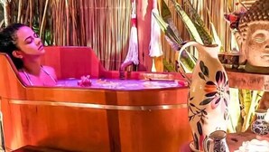 A room with a thatched roof, a wooden bathtub, and a table with a floral pitcher. - Casa das Rendas Exclusive Bungalows (Amontada)