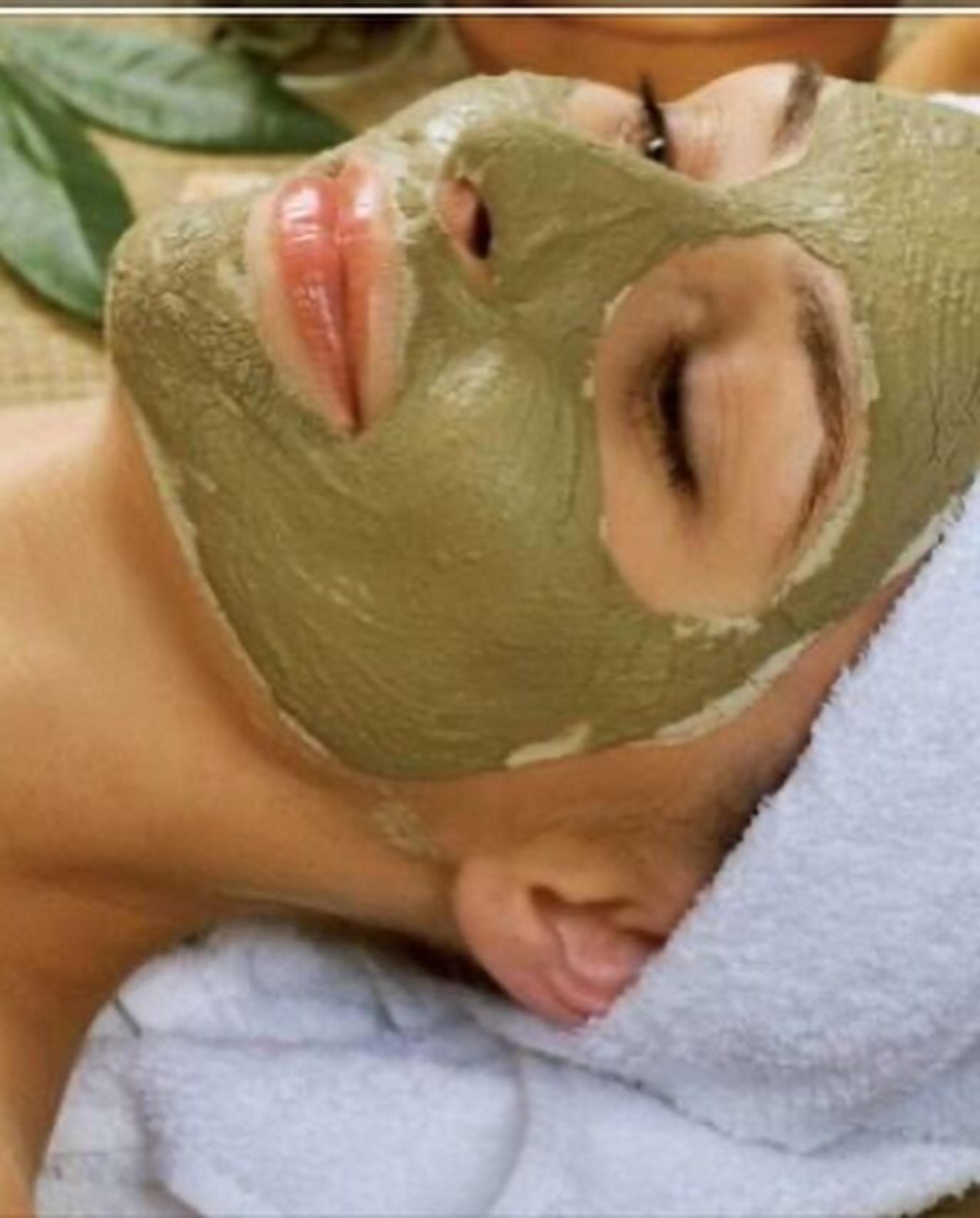 Una persona con máscara facial verde, acostada con una toalla.