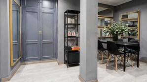 A modern dining area with a dark grey wardrobe, a black bookshelf, and a dining table with chairs. - Holi-Rent Gran Poder (Sevilla)