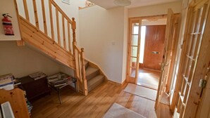 Eine Treppe führt zu einer zweiten Etage, eine Holztür und ein Flur mit einem Teppich.