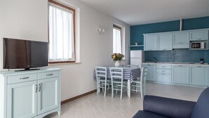 En modern lägenhet med matplats, kök och vardagsrum.