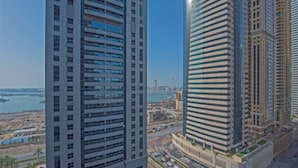 Ein Hochhaus mit modernem architektonischen Design, das eine geschwungene Fassade und einen markanten Eingangsbereich mit angelegtem Garten aufweist.