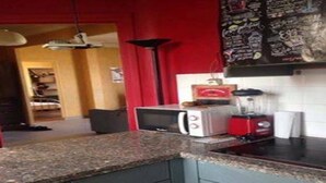 A kitchen with granite countertops, a microwave, a red toaster, and a blender on the counter. - 70m2 apartment in the district of the barracks of Bonne (Grenoble)