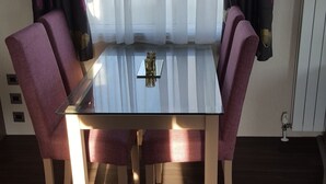 A compact room with a bed, a small table, and a chair.