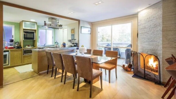 Una cocina moderna con comedor, chimenea y vistas al exterior.