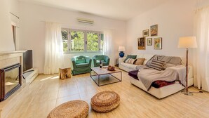 A living room with a fireplace, a sofa, a coffee table, and a television. - Maria Bonaire for eigth people with pool (Alcúdia)