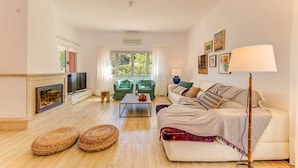 A living room with a sofa, two armchairs, a coffee table, a TV, and a fireplace. - Maria Bonaire for eigth people with pool (Alcúdia)