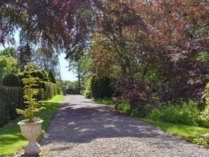 A gravel pathway flanked by neatly trimmed hedges and trees with autumn foliage. - 1 bedroom accommodation in Pitscandly, near Forfar (Pitscandly, near Forfar)
